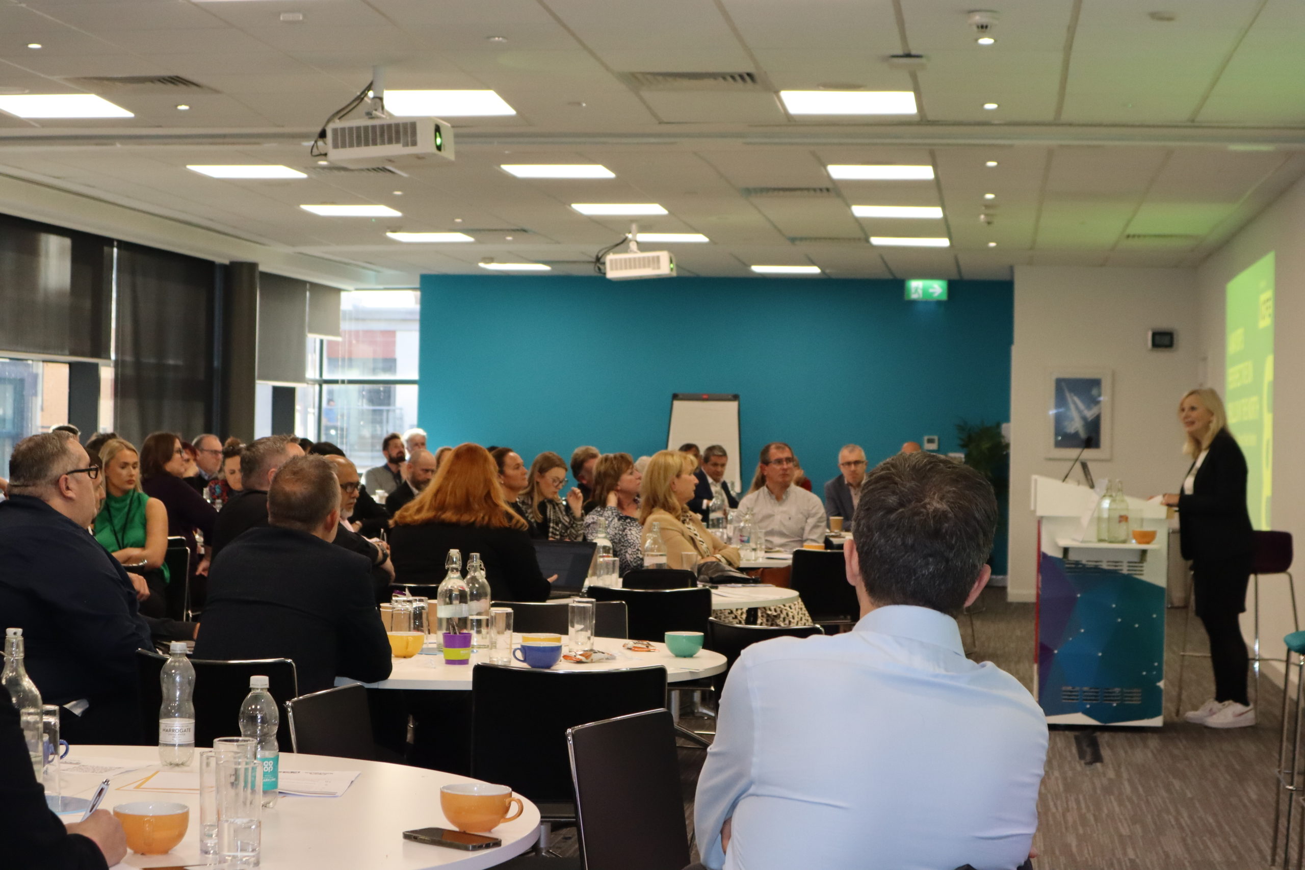 An image of a room full of people listening to a guest speaker at the Northern Skills Network Conference from 2023 October.